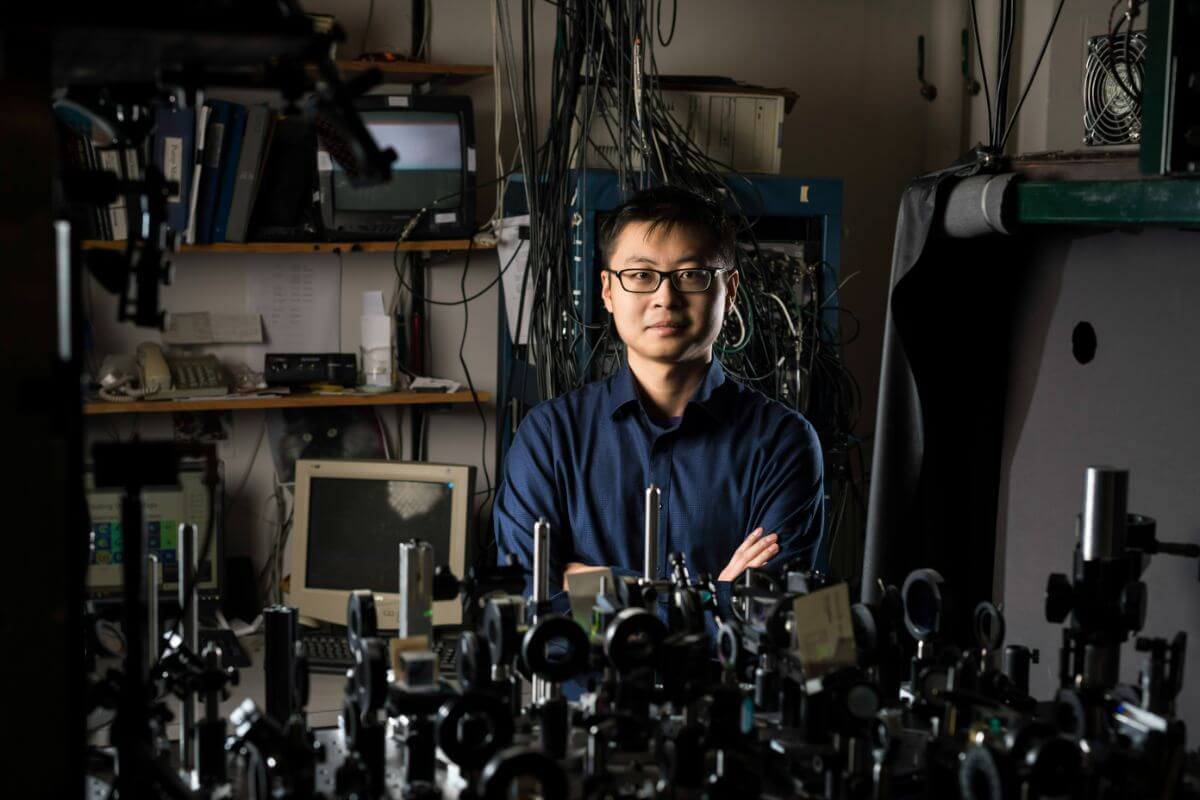博士生陈泽凯在他的导师、物理学教授尼古拉斯·P·科斯的实验室里拍照. 毕格罗，在鲍什 & 随着大厅.